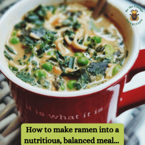 Mug of ramen noodles with spinach, peas and peanut butter.